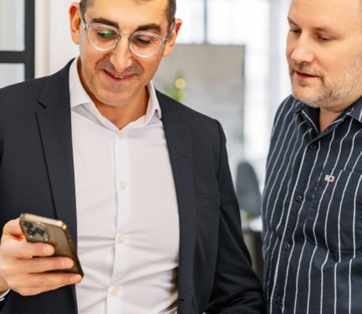 Two 7N male staff members looking at the phone